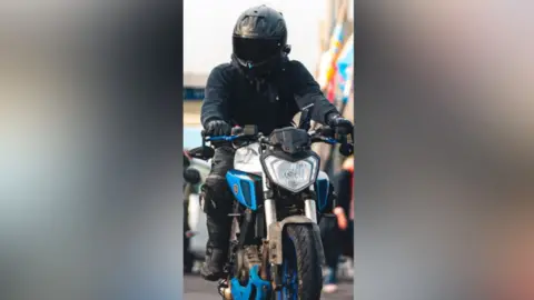 Dorset Police Someone driving a blue and silver motorbike.