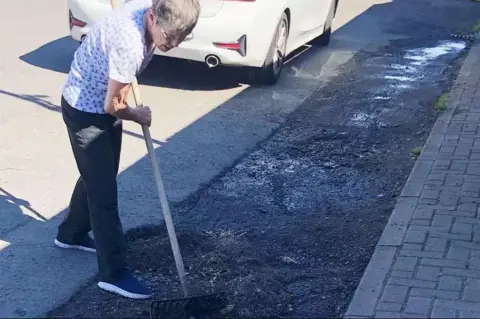 SWNS Jenny Paterson filling in potholes at her home in Caithness