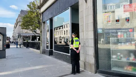 Police officer outside a building in Aberdeen's Union St