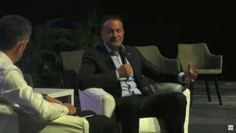 BBC Man sitting in chair speaking on stage 