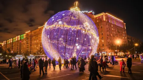 Orang-orang EPA berjalan melewati dekorasi jalanan untuk liburan Natal di Moskow, Rusia, 06 Januari 2025.