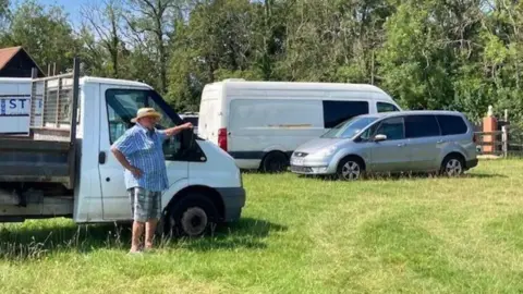 Christine Godfrey A man standing by a van in a field