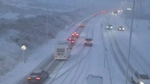 The A465 with snow on the dual carriageway and traffic moving slowly.