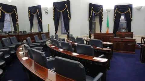 Getty Images Ireland's Seanad chamber, also known as the upper house of the Irish parliament, is pictured in Leinster House in Dublin, Ireland, on October 2, 2013. Rows of seating can be seen facing towards desks with the Irish flag on the back wall.