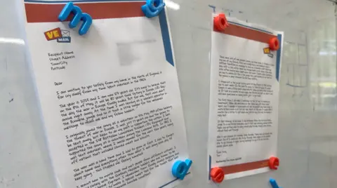 Tom Jones' letter on display at the school. It is stuck onto a whiteboard by several magnets.