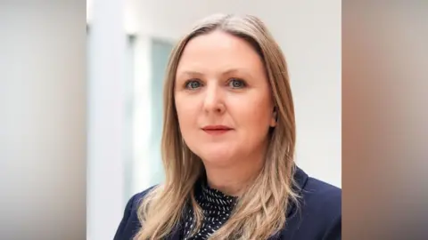 Sam Dennis is pictured. She is a white woman with long blond hair.