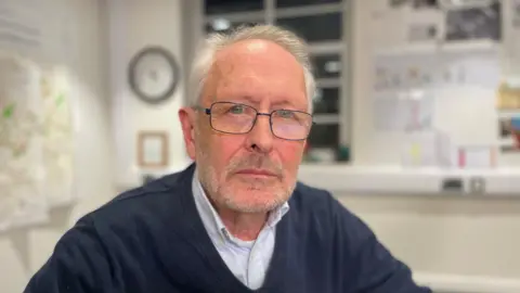 A man in a blue sweater