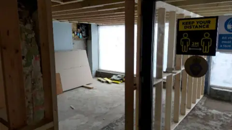 AFCF / FREEDOM OF INFORMATION An office space under renovation with wooden joists in the background and a temporary wall.