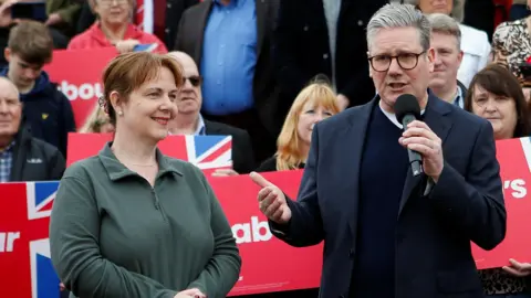 Claire Ward stood next to Keir Starmer on a campaign visit infront of labour party signs