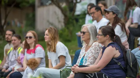 Eden Project Communities A crowd of people sitting down and listening to a talk on sustainable food and food waste