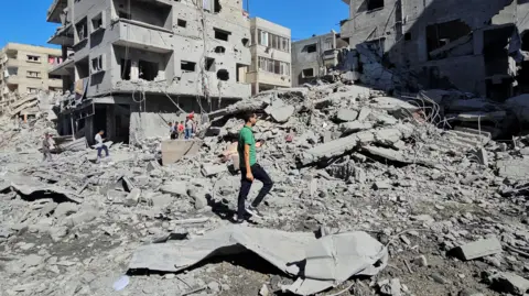 Reuters Palestinians gather at the site of Israeli strikes on houses and residential buildings, amid the ongoing Israel-Hamas conflict