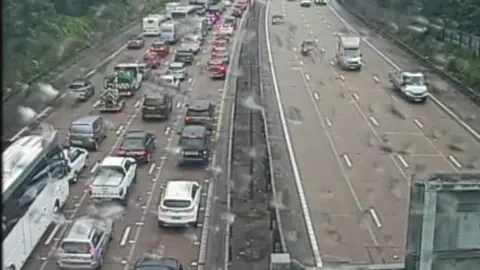 Traffic builds up on one side of a duel carriageway. On the other side, vehicles drive freely