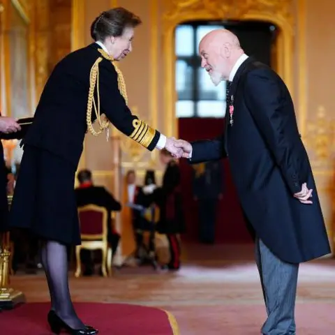 PA Media Bill Bailey shakes hands with the Princess Royal