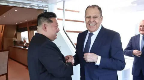 North Korean leader Kim Jong Un shakes hands with Russian Foreign Minister Sergei Lavrov during a meeting in Wonsan, North Korea