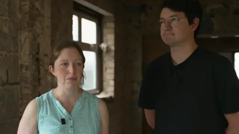 Freya and Alex standing in their home under construction