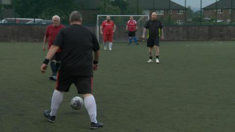 Men playing football under the Man v Fat campaign