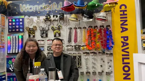 Eda Luo, Sales Manager at Wonderful Party, and a male colleague at his booth at Toy Fair