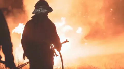 Fire fighter battling wildfire