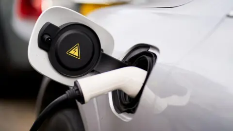  John Walton/PA Media File photo dated 05/03/21 of an electric car plugged into an Ubitricity lamppost EV charging point in central London