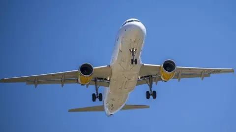 Picture of the underside of an unmarked plane coming in to land
