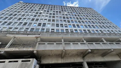 A big Brutalist 1960s concrete building called Terminus House in the centre of Harlow, with many windows.