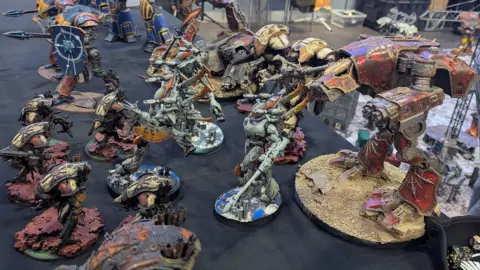 A tabletop with several painted Warhammer figures.