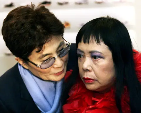 Getty Images Yoko Ono leaning and speaking to Yayoi Kusama in 2000