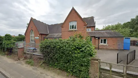 Exetrior image of Woodton Primary School - a red brick building with gabled roof.