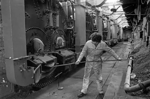 National Mining Museum Scotland A black and white picture from the 1970s shows a worker stokes one of the boilers at the colliery site.
