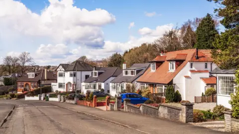 Getty Images A street of large houses, framed by mature trees, in the affluent Glasgow suburb of Bearsden