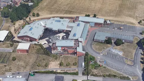 Google An aerial view of the school. It is a mixture of single storey buildings with a car park.