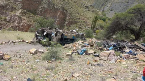 A damaged bus is seen on the ground after a deadly crash which killed more than 30 people in Yocalla, Bolivia.