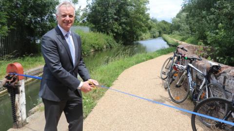 Aylesbury MP Rob Butler cutting the ribbon to officially launch the new towpath, in Aylesbury
