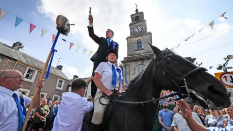 Getty Images A man on horseback stands in front of the town clock in Langholm