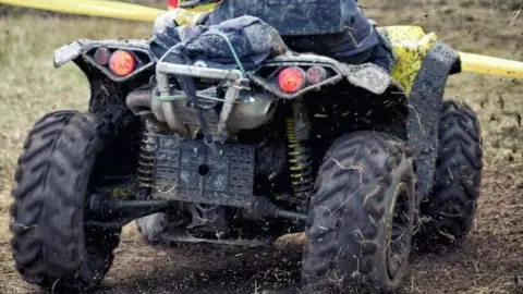 Getty Images Close up of the rear of a quad bike on a dirt track
