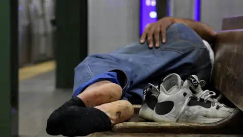 Reuters A homeless man sleeping on a bench