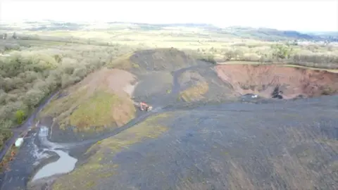 Daniel Therkelsen / Coal Action Network Drone image of a quarry, surrounded by trees, witha  digger visible in the middle.