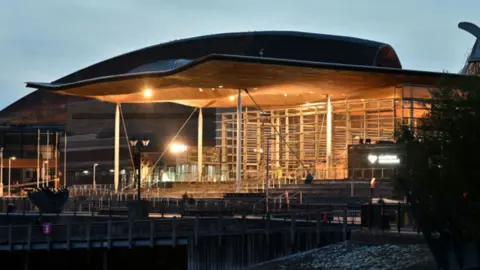 Getty Images An exterior picture of the Senedd building with its lights on in the early evening.