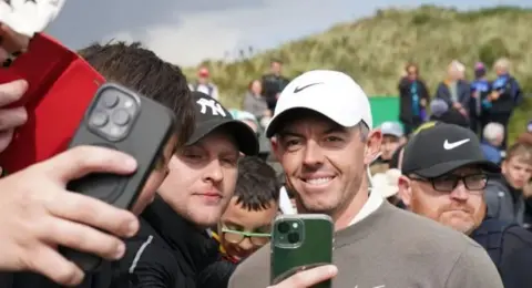 Rory McIlroy having a photo taken with a fan