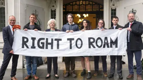 A number of people holding a banner saying right to roam.