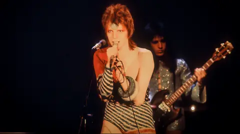 Getty Images David Bowie wearing a striped sequin leotard while performing as Ziggy Stardust in 1972