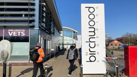 A view of people walking into Birchwood Shopping Centre