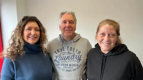 BBC Maria Ann Laver, Paul Cherrison and Kate Whoriskey smiling, looking straight at the camera, in the cafe of Cascades leisure centre, Gravesend.