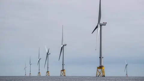 Getty Images A row of wind turbines in the sea. It is very grey.