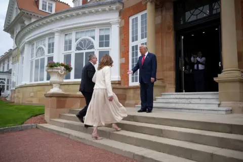 Getty Images PM Starmer and his wife Victoria are walking steps from the golf club, where Trump welcomes them with a paid hand