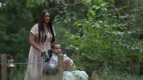 BBC Mum Kareema and son Jayden in the garden with Jayden in a wheelchair
