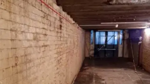 LDRS The inside of a white brick tunnel in a rundown state