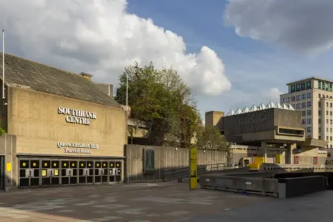 The Southbank Centre A brutalist building and the entrance to the Queen Elizabeth Hall. Outside is plain brown concrete. 