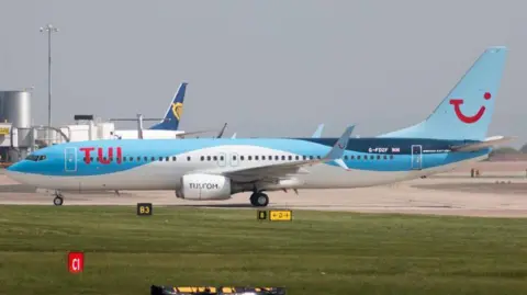 Juha Remes via Getty Images A Boeing 737-8K5, in sky blue TUI livery, sits on a runway at Manchester Airport.