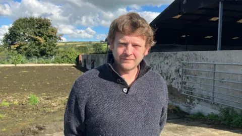 Farmer Gary Howells stands in front of slurry pit.